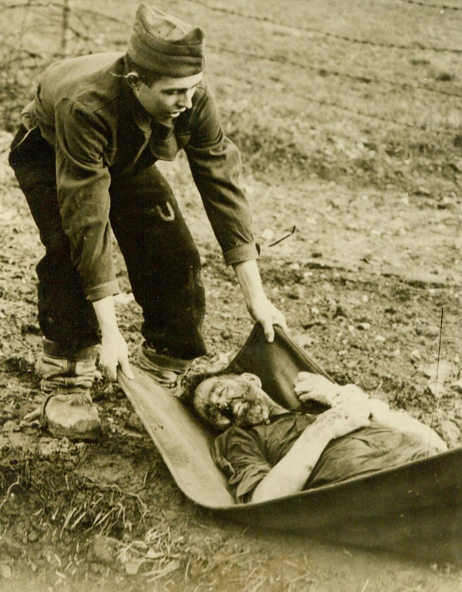 Bury The Dead In Nazi Prison Camp, 12/20/1944. France -- A prisoner who died in the former German Prisoner-Of-War camp at Sarreguemines, France, on the U.S. 3rd Army front, is being removed by one of his comrades for burial in a common grave. Yanks captured the camp December 11. Prisoners included about 1,000 Russians, Serbians, Italians, Poles, And French, some of whom had been in German hands since Nazis entered Warsaw more than five years ago. 12/20/44 (ACME);