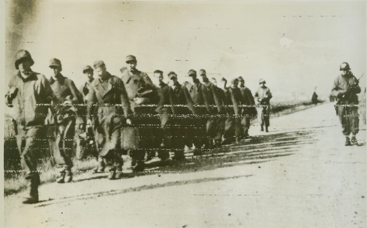 Nazis captured in new Allied thrust, 1/24/1944. Italy – A column of captured German soldiers are marched to the rear by Fifth Army fighters taking part in the new Allied thrust toward Rome. The American, British and French assault troops have drive four miles inland and are reported only 30 miles from their goal, Rome. Credit: Stars and Stripes photo via OWI Radiophoto from ACME;