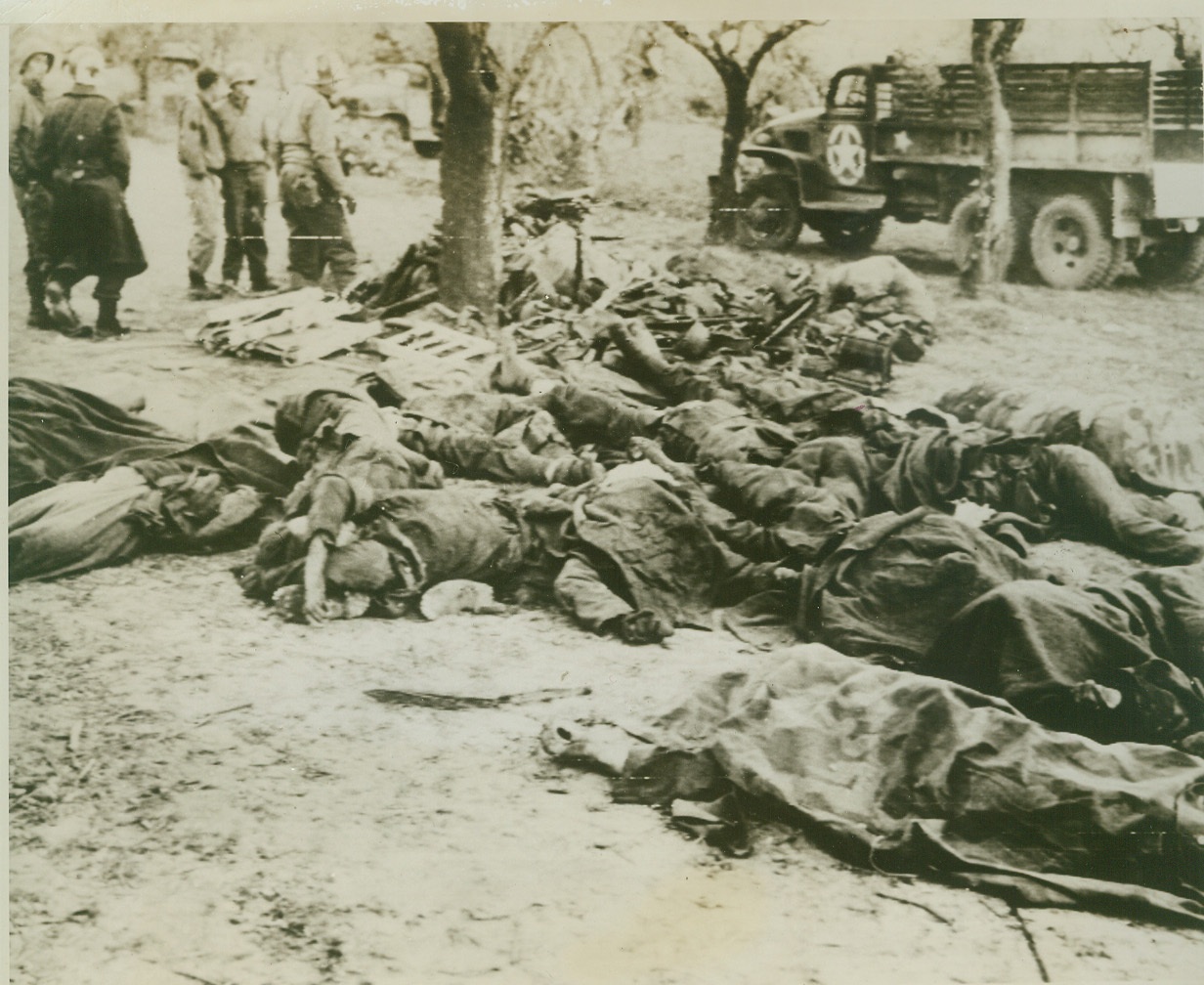 They Died for Hitler, 1/21/1944. San Vittore, Italy – A flock of fallen Nazi warriors lies, with a batch of German equipment, on the ground at San Vittore collecting point. American Medical Corps personnel can be seen in background. Credit: (U.S. Army Radiotelephoto from ACME);