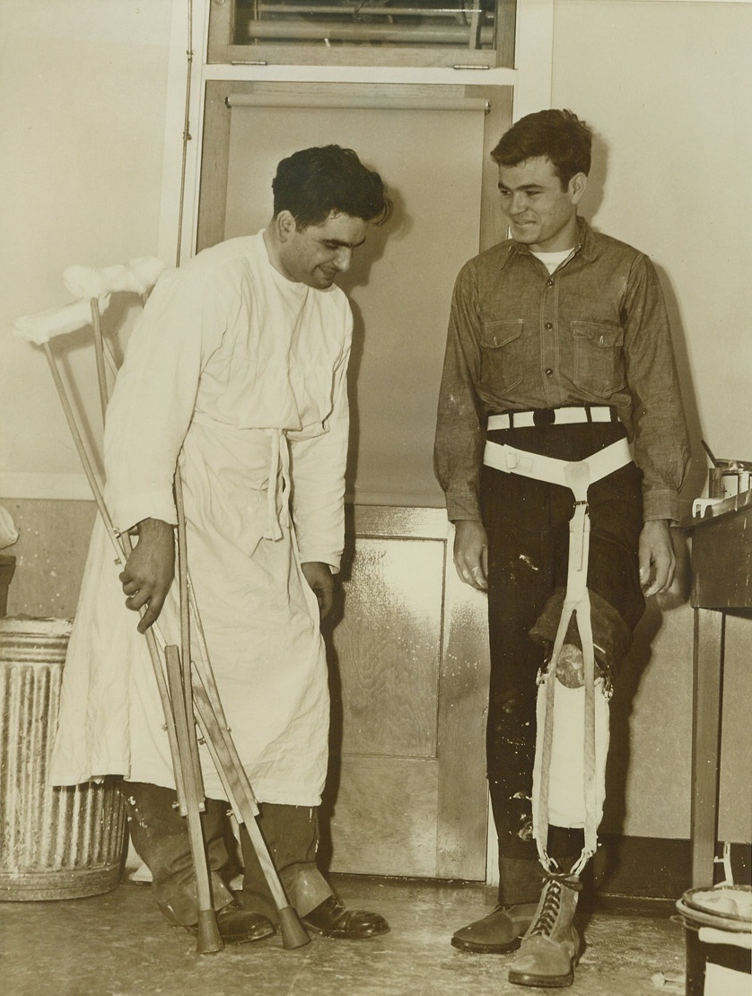 New Leg for Crippled Veteran, 1/20/1944.Mare Island, Calif. – S.C. Blankenship, ship cock 3/C of Alum Creek, Va., tries out his new, temporary artificial leg, watched by Matt Lawrence, in charge of the artificial limb department at the Mare Island, Calif., U.S. Naval Hospital. A plastic and steel limb will replace this temporary one, fitted to Blankenship barely six weeks after he lost his own leg from action on Vella Lavella. Credit: (ACME);