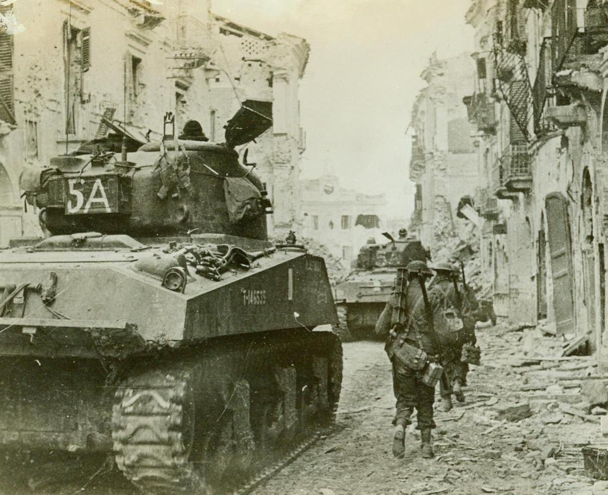 CANADIANS FINISH OFF NAZIS IN ORTONA, 1/20/1944. ORTONA, ITALY – Canadian tanks and infantrymen advance through the battered streets of Ortona, Italy, for the last phase of five days of bitter street fighting to wrest the Adriatic coastal town from German control. Dead Nazis, which littered the streets, were identified as belonging to enemy paratroop regiments. Credit Line (ACME);