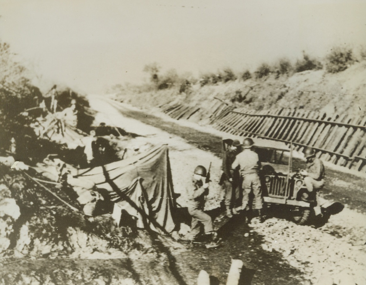 Taking the “Rail” Out of "Railroad”, 1/19/1944. ITALY—Allied Engineers ripped this railroad up and built a road for the advance against the German at Mt. Porchia and Mt. Trocchio. Here, American troops utilize dugouts built by the Germans. Rails and ties from the railroad lie along the right bank. Today, the Allies crossed the vital Garigliano River setting up a strong bridge head on the North bank. Credit: U.S. SIGNAL CORP RADIOTELEPHOTO from ACME.;