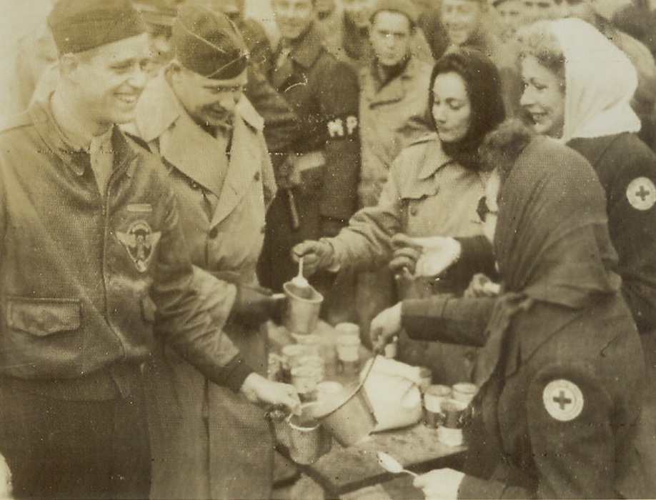 Doughnuts for a Roosevelt, 1/19/1944. ITALY—Col. Elliott Roosevelt, (far left), son of President Roosevelt, is served doughnuts and coffee near the front in Italy by American Red Cross girls. Credit: RED CROSS PHOTO thru OWI RADIOTELEPHOTO.;