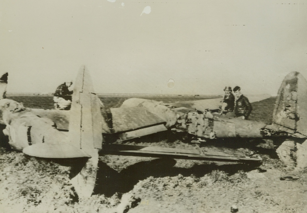 Collides with Nazi in Mid-Air, 1/28/1944. First Lt. Thomas Smith, of Madera, Calif., explains a few breath-taking facts to his flight leader, 1st Lt. Robert L. Highsmith, of Lombard, Ill. Piloting his P-38 Lightning, he collided in mid-air with a Nazi fighter plane, scraping the right engine and setting it afire and slicing the tail boom in two. After two hours in the air, when the second engine failed, Lt. Smith landed the battered plane in a wheatfield adjoining his base. Credit: SIGNAL CORPS RADIOTELEPHOTO FROM ACME.;