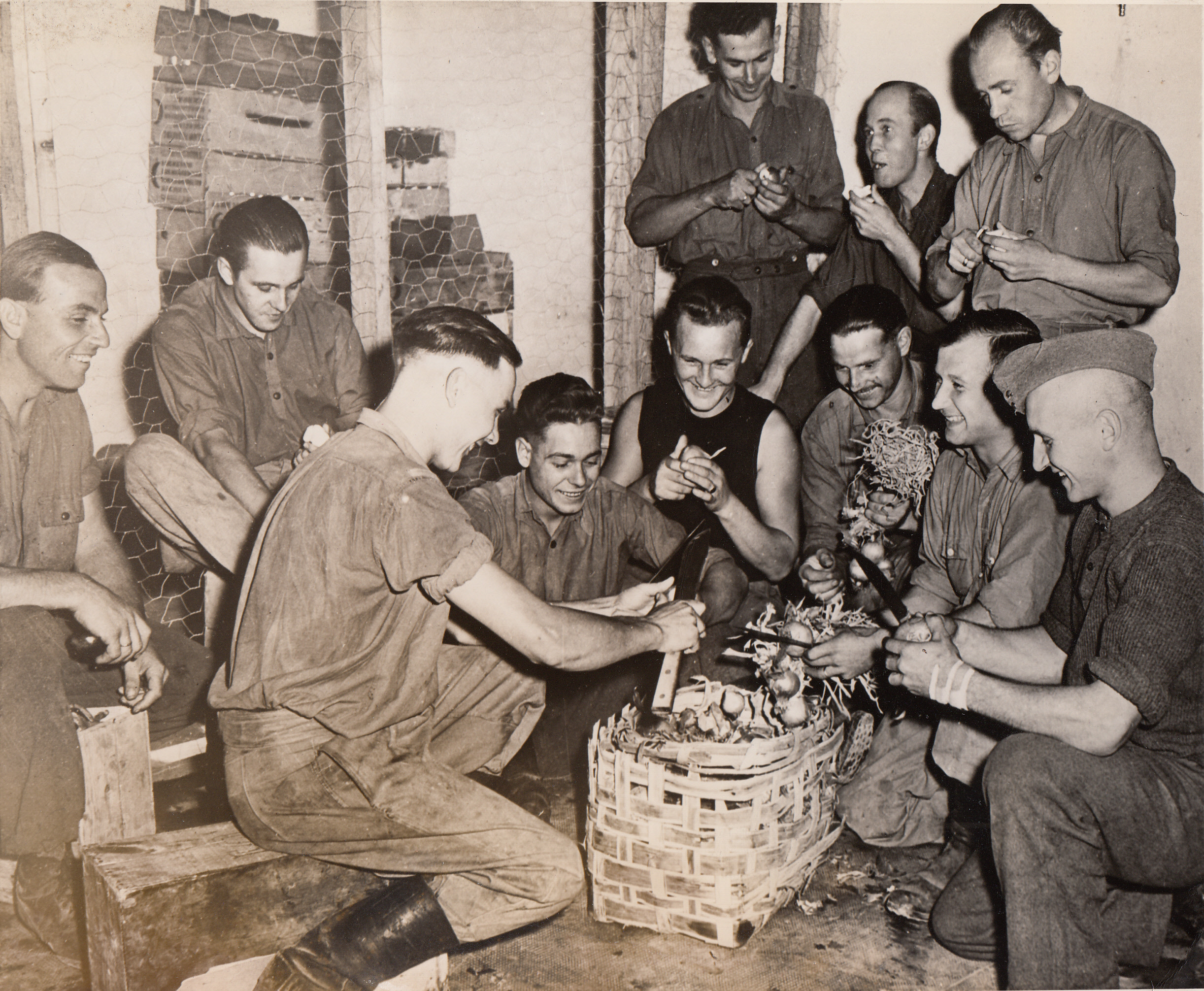 Onions Bring No Tears to German Eyes, 1/4/1944. ITALY—Behind the battle lines in Italy, Nazi prisoners of war do K.P. duty with a smile, even though they are peeling onions for soup. Many of the captured German soldiers arrived at the prison camp bearing leaflets, fired from Allied guns, which described the excellent treatment they would receive on surrender.;