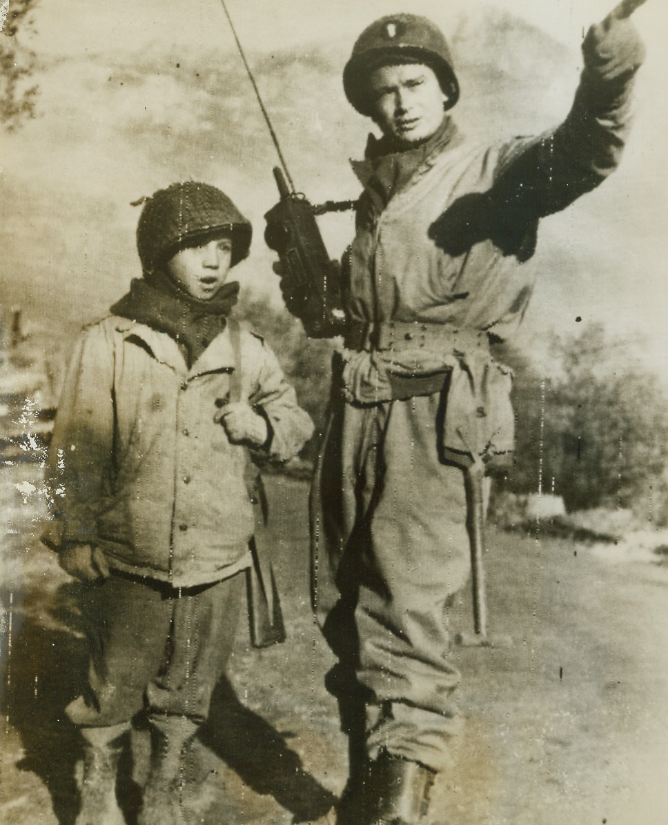 Mascot of the Yanks, 1/5/1944. ON THE FIFTH ARMY FRONT -- The only member of his family who survived the bombing of Avaline, ten-year-old Tony Mao has been adopted by Yanks of the Fifth Army. Strictly “G.I.” in clothing and conversation, the little boy gets directions for an errand from Lt. Anderson Smith of Barnesville, Ga. Credit: OWI RADIOPHOTO from ACME;