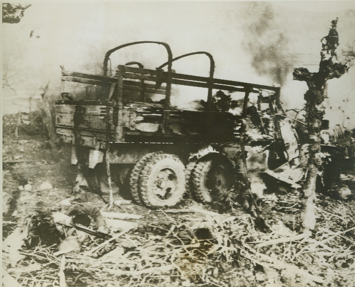 Funeral Pyre for Prisoners, 1/18/1944. SOMEWHERE IN ITALY -- This burning truck became a funeral pyre for German prisoners of war, who were riding into captivity when the truck was bombed and strafed by Nazi planes. The body of one of the prisoners who tried to escape from the flaming truck can be seen at lower left.  Credit (U.S. Signal Corps Radiotelephoto - ACME);