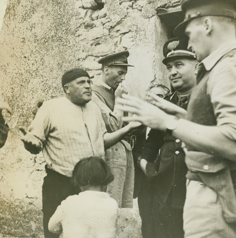 Suspected Hoarded, 1/15/1944. PALERMO, ITALY – Suspected of hoarding wheat, this Sicilian land owner vehemently protests an inspection of his storage bins by officials of the Allied Military Government in Palermo. But, the AMG, whose job it is to distribute food equally among civilians in occupied territories, went ahead and searched—to find that the suspect had declared only one-third of his wheat supply. The wheat was confiscated and hauled to a central storage bin. Later, a jury found the owner guilty of hoarding and the confiscation became permanent.Credit Line –WP – (ACME);
