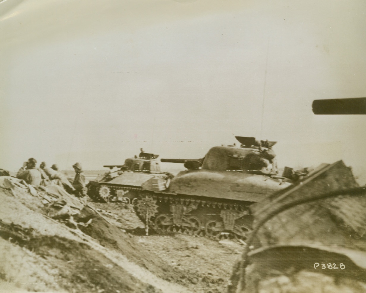 Keeping Track of the Nazis, 1/29/1944. NETTUNO, ITALY – Before advancing, Fifth Army tankmen leave their armored vehicles to scan the plains near Nettuno, Italy, for any signs of the enemy who were completely surprised by the Allied amphibious landings south of Rome. They park their war machines in a ravine in the Mussolini Canal sector of the new front.Credit (Acme Photo by Bert Brandt, via Signal Corps Radiotelephoto;