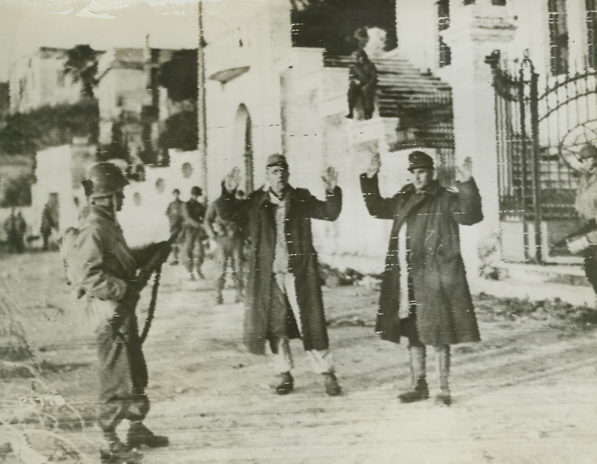 NAZIS SURRENDER, 1/27/1944. NETTUONO, ITALY—Holding their hands high, a pair of Nazis surrender to Fifth Army men in Nettuono. Our fighters reached the town shortly after making their surprise landing at Anzio, Italy. Credit: U.S. Signal Corps radiotelephoto from Acme;