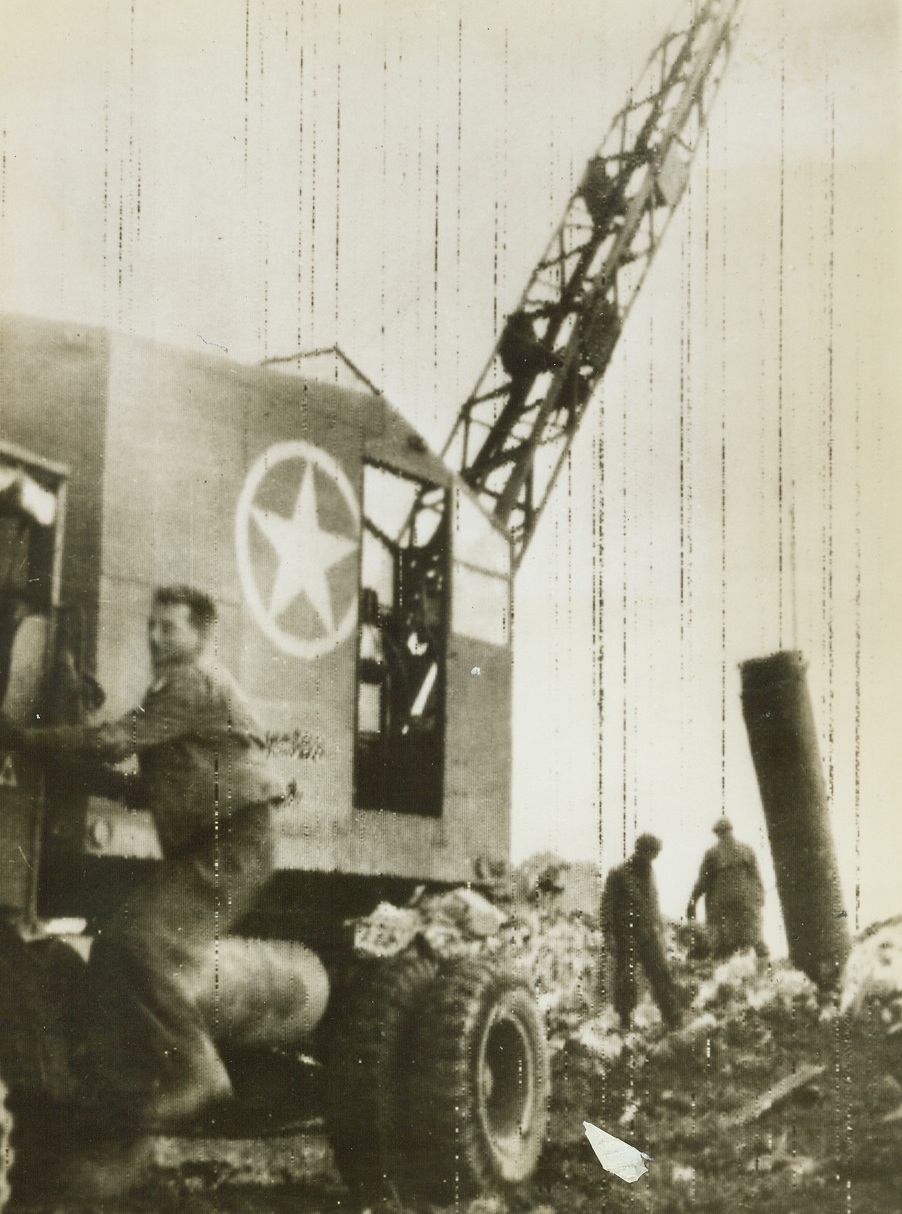 Cleaning up on Road to Rome, 1/26/1944. Anzio, Italy – An American Army crane hoists a 300-pound Tronite demolition charge from the spot on the beach at Anzio, where it had been planted by the Germans who hoped to kill Allied invaders with it. Now, streams of men and material are pouring ashore at Anzio and at other bridgeheads south of Rome and the Allies are pushing inland to cut lines of retreat of Nazis trapped to the South. (Passed by Censors) Credit: Stars and Stripes photo via OWI Radiophoto from ACME;