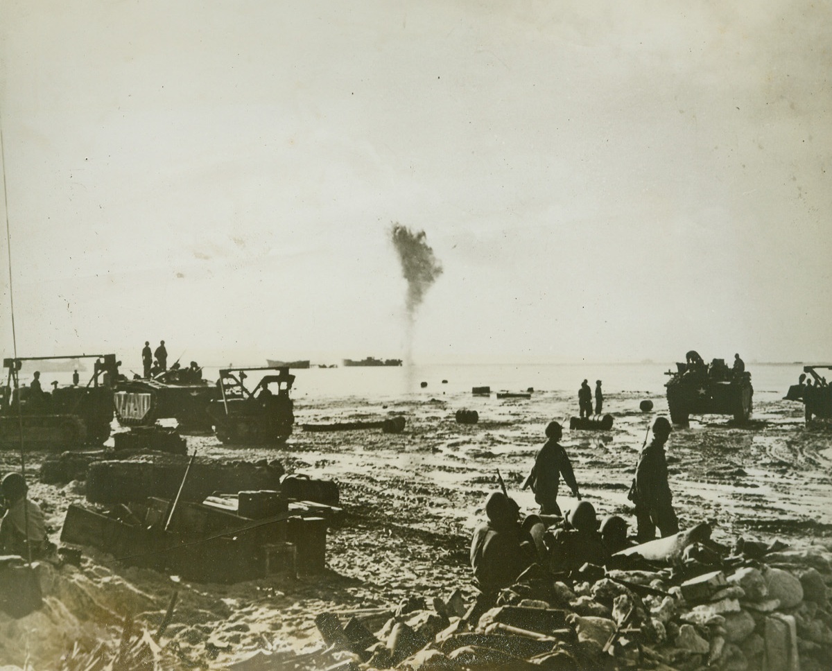 Major Operation, 1/6/1944. Makin Island --- In operations designed to destroy all Jap machine gun nests, Navy dive bombers drops loads of explosives on two old hulks of ships off Ah Chongs Wharf, Butaritari Lagoon, Makin Atoll.  Column of smoke rises from one of the ships.  Makin was occupied by units of the 165th infantry, 27th division, formerly the fighting 69th of New York.Credit (Signal Corps photo from ACME);