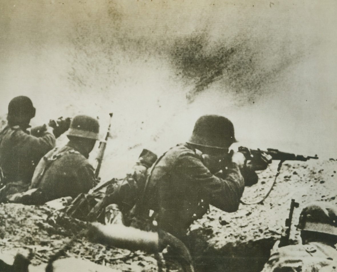 A “Hot One” for Fritz, 1/20/1944. A Russian shell bursts on the parapet of a German trench “somewhere in the South Russian front,” in this photo just received from a neutral source. Nazi soldier, in foreground, ducks the shower of dirt and shell fragments, while his comrades keep firing their rifles. Today it was announced that the key city of Novgorod in North Russia has been captured from the Germans, while the Soviet advance in the south continues. Passed by censors.Credit: ACME;