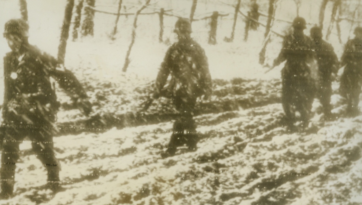 ”To the Rear—Slosh” for the Nazis in Russia, 1/4/1944. RUSSIA—Although news dispatches describe the Nazis as “reeling” backward before the Russians, actually the German soldiers are slogging and sloshing their way in retreat to the west. Here, enemy infantry troops wade ankle-deep in cold, cold mud with a mechanized wake of Russians. Photo radioed from Stockholm to New York today.Credit: ACME;