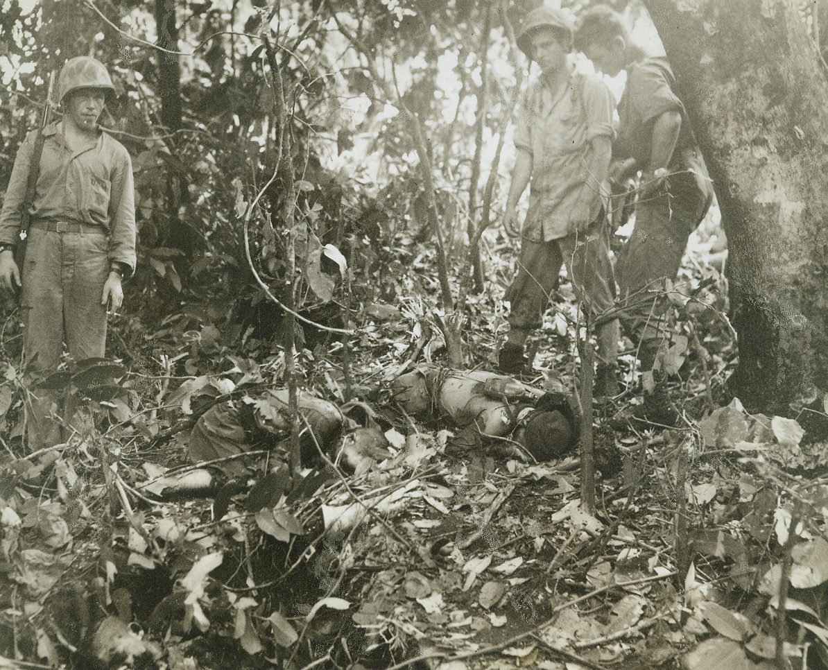 Well, They Tried…., 1/18/1944. NEW BRITAIN – A group of leathernecks looks down at the bodies of Jap soldiers who tried to hold their pill box at all cost in the battle for Cape Gloucester. The enemy fighters were made to pay the price by our convincing 75mm Howitzers. Credit: ACME photo by Frank Prist Jr. for the War Picture Pool;