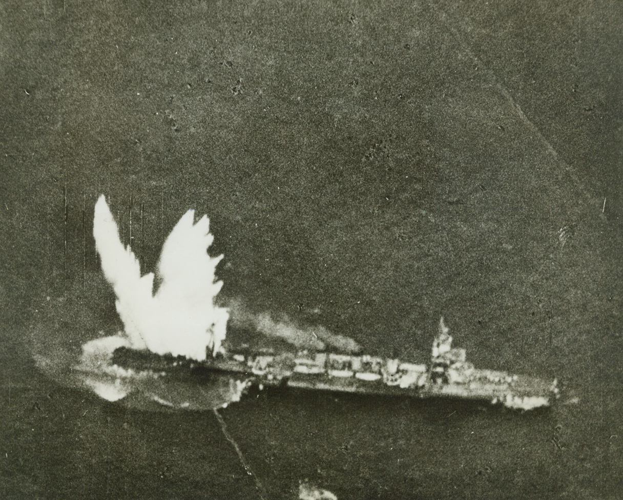 “Dive Bombers Paradise, Japanese Hell” – 2, 1/28/1944. Marshall Islands – A towering plume of white shoots far over the stern of  a Japanese light cruiser of the Kuma class as an American torpedo strikes home while (upper right) the wake of another torpedo released by a Grumman avenger is clearly seen.  The second torpedo plowed harmlessly past the bow of the ship, one of two light cruisers sunk in the December 4, 1943 Navy task force raid on Kwajalein Atoll in the Marshalls where the enemy lost 72 planes, two light cruisers, three cargo vessels and a large tanker.  Four other cargo ships sustained direct hits and were left smoking by our carrier-based dive bomber, torpedo and fighter planes. Credit (Official U.S. Navy photo from ACME);