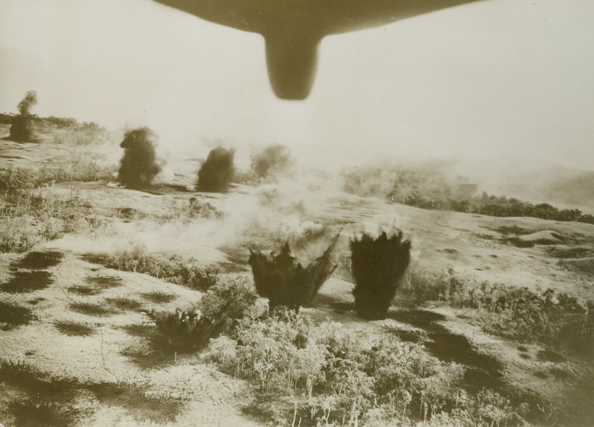 Fresh “Eggs” for Japs, 1/26/1944. Bombs from planes of the U.S. Army 5th Air Force, explode on installations and the Jap airfield at Cape Gloucester, in this photo just released in the U.S. The raid was part of the “softening up” process which preceded the Allied landing at the Southwest Pacific island of New Britain. When the landing was effected, American engineers immediately set to work to put the airfield in shape for use against the Jap base of Rabaul, New Britain.Credit: U.S. Army Air Force photo from ACME;
