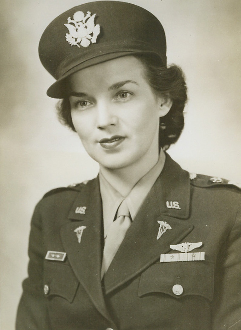 Flight Nurse Wears Her New Gold Wings, 1/14/1944. Captain Juanita Redmond, of the Army Nurse Corps, proudly wears the gold wings of a flight nurse above her National Defense and Pacific-Asiatic Theatre Ribbons, both of which bear the stars of combat areas. The wings have just been adopted as the insignia of the Army’s flying nurses. Captain Redmond, who hails from Swansea, S.C., also wears the Presidential Unit Citation Ribbon, with the stars representing Bataan and Corregidor. She is now attached to the Office of the Air Surgeon in Washington, D.C.Credit: U.S. Army Air Forces photo from ACME;