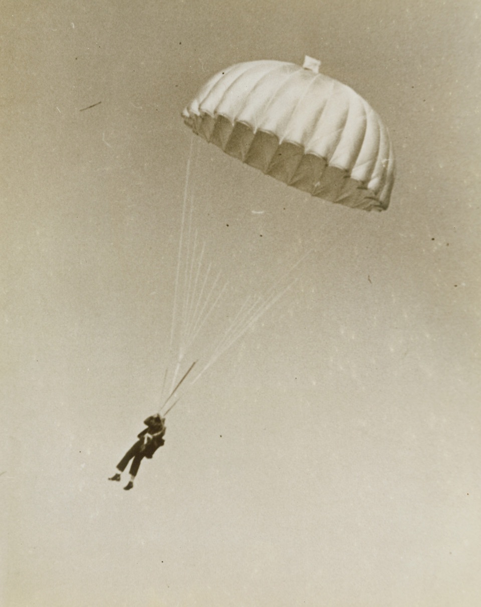 As His Plane Goes Down in Flames, 1/22/1944. San Francisco - Hitting the silk to safety, Lt. Harry E. Pape floats earthward after his fighter-plane plunged out of control 6,000 feet over Oakland, Calif. Pape’s only injury was a wrenched knee suffered on landing, but the burning plane injured 10 when it crashed into a building at the Alameda, Calif., Naval Air Station. Credit: U.S. Navy photo from ACME;