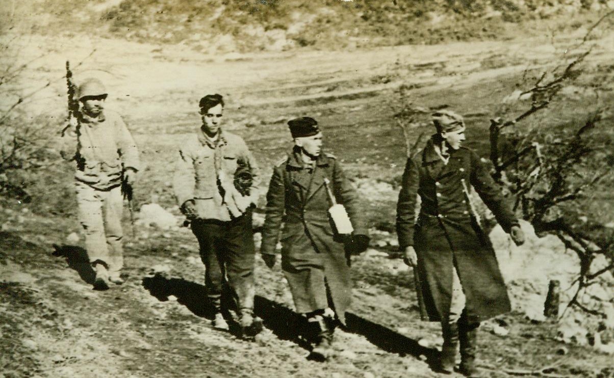 A short war for these Germans, 1/13/1944. MT. PORCHIA, ITALY – Pfc. Ira C. Creed, (left), of Johnson City, Tenn., marches three green recruits of the famous Hermann Goering Nazi Division down the side of Mt. Porchia, after capturing them single-handedly. The prisoners, who admitted they had only a little infantry training, were on duty in the front lines for only one night when he captured them behind a rock. They are shown on their way to a prisoner of war camp. CREDIT LINE (U.S. Signal Corps Radiotelephoto from ACME) 1-13-44;