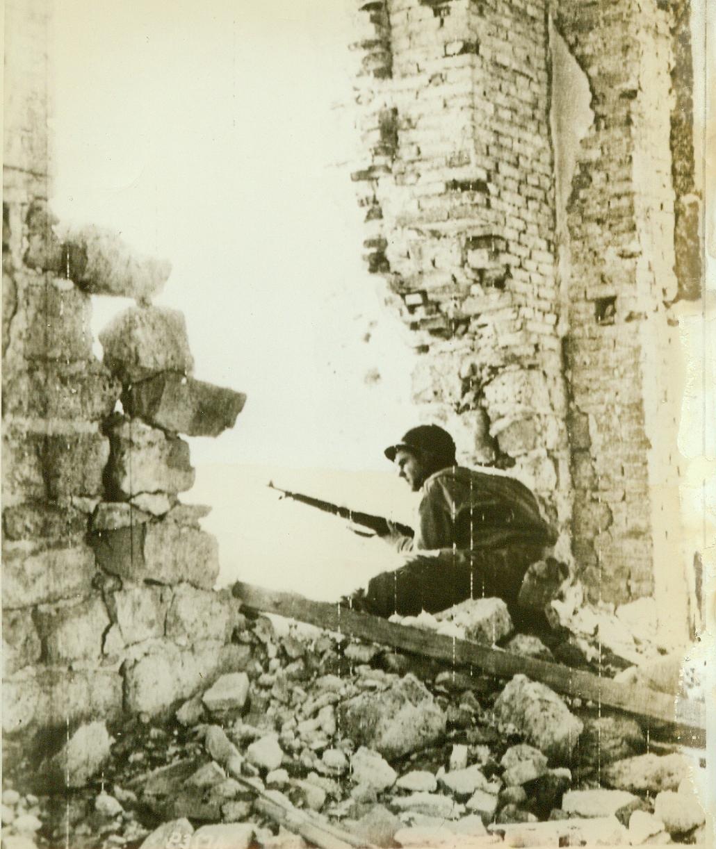 Looking for snipers, 1/11/1944. SAN VITTORE, ITALY – An American soldier peers carefully through a breach in a wall of a blasted building in San Vittore, keeping a sharp watch for German snipers remaining in the town after it was occupied by the Allies. This photo was flashed to the U.S. by radiotelephoto. CREDIT LINE (ACME ) 1-11-44;