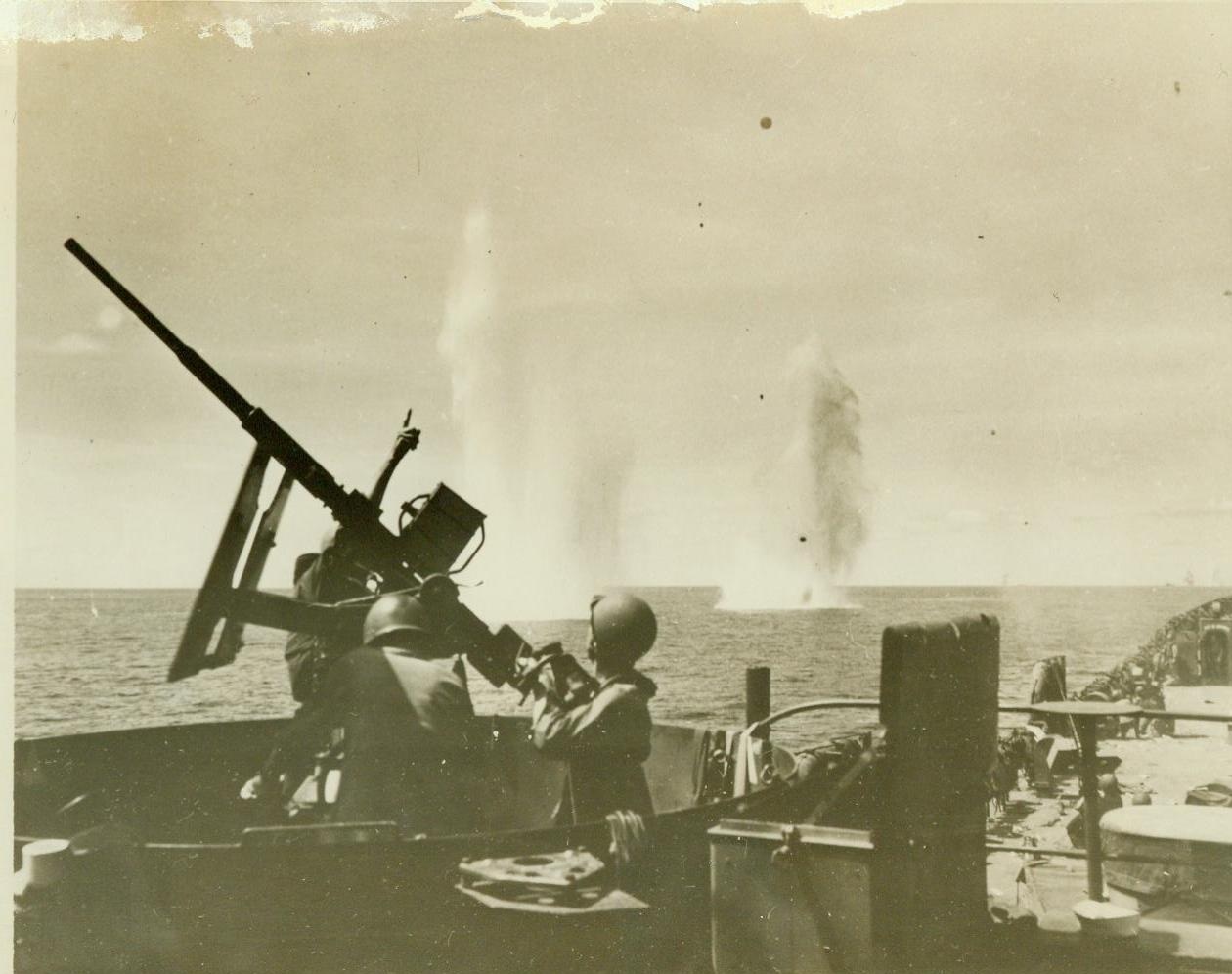...Guard Gets Some Near Misses, 1/10/1944. ...BRITAIN - Far too close for comfort...the white geysers that mark Jap bombs...near an American LST (Landing Ship...) which aids the invasion of Cape...New Britain. Behind the...anti-aircraft gun, a U.S. Coast Guardsman...at the sky and an enemy plane.;