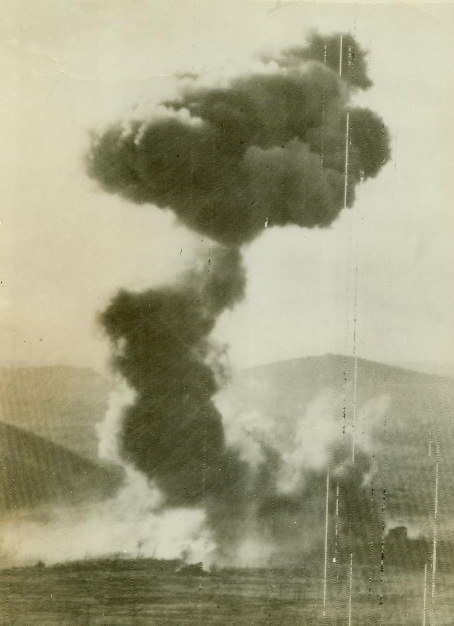 Long range scorched Earth policy, 1/10/1944. ITALY – The Germans evidently had to leave so quickly from Cassino Valley that they didn’t have time to destroy equipment and supplies which they were forced to leave behind. Here a German shell hits their own own gasoline and oil dump abandoned in their retreat from San Vittore. The hit throws flame and smoke 2,000 feet high over the valley. In the foreground are farmhouses which the Nazis had used as pillboxes. CREDIT (ACME) 1/10/44;