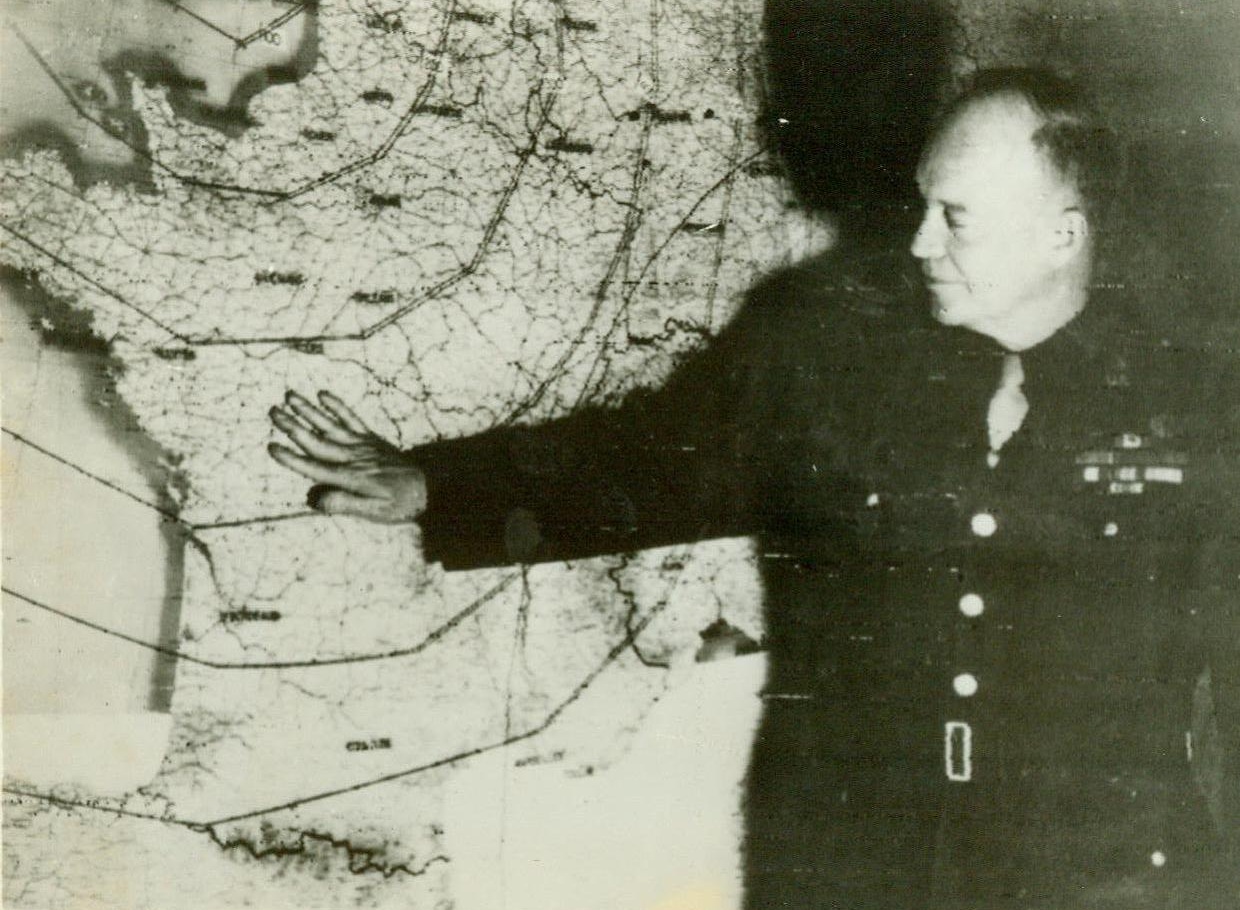 When We Strike......, 1/17/1944. London— Running his hand over the territory occupied by Hitler, as shown on a wall map at London Headquarters, General Dwight D. Eisenhower Commander-in-Chief for the forthcoming invasion of Europe, is shown during his press conference, held today (January 17th).  1/17/44 (RadioPhoto);
