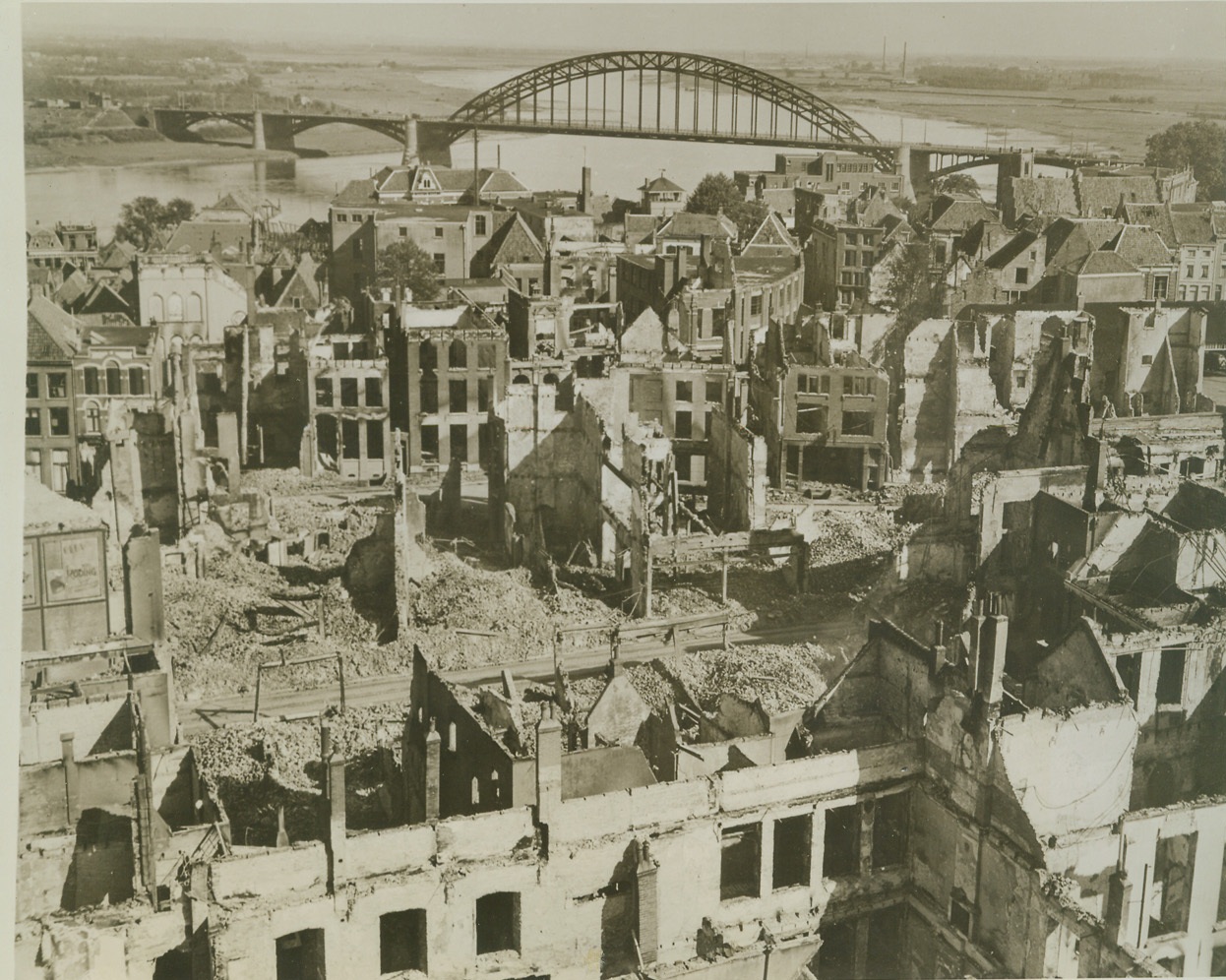 Devastated NiJMegen, 10/5/1944. Holland – Burned out shells of buildings and piles of rubble mark this view of the war-blasted town of NiJMegen after its capture by the Allies. In the distance, is the key bridge over the Waal (River) captured intact in the rapid advance. Credit: (Army Official Photo from ACME);