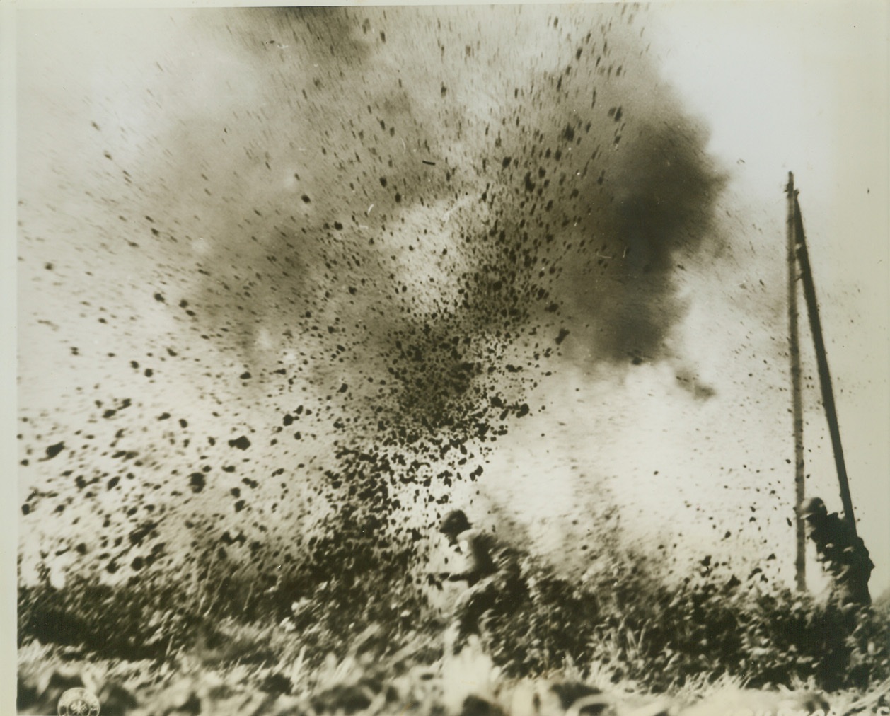 Yanks Barge Through Shell Burst, 10/13/1944. Holland – American paratroopers bend low but continue their advance on Arnhem as a bursting German 88 kicks up a section of field. Credit (Signal Corps Photo from ACME);