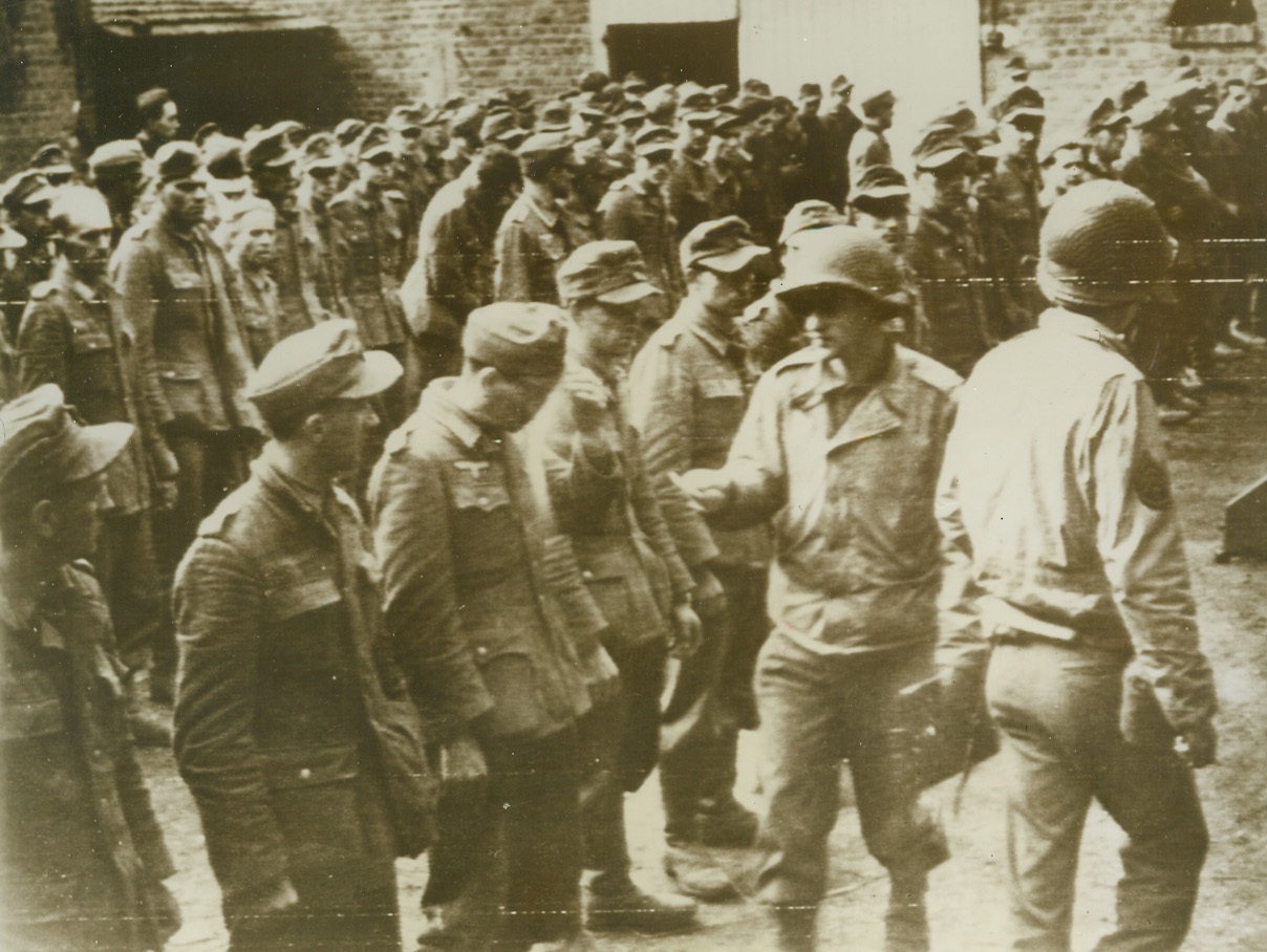 Captured in Siegfried Breakthrough, 10/5/1944. An American officer checks the first large group of Nazi prisoners captured by the Yanks, after their breakthrough of the Siegeried line at Uebach, Oct. 4. Credit: ARMY RADIOTELEPHOTO from ACME.;