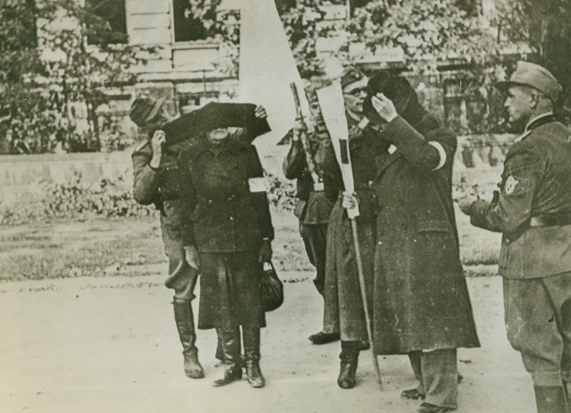 WARSAW POLES SURRENDER, 10/25/1944. Two Polish delegates of the Warsaw resistance group, a man at right and a woman, are blindfolded by Nazi soldiers before being passed through German lines after the premature uprising in the Polish capital was quelled by Hitler’s occupation forces. This photo, radioed to London from a neutral source, has just been received in New York. Credit: Acme;