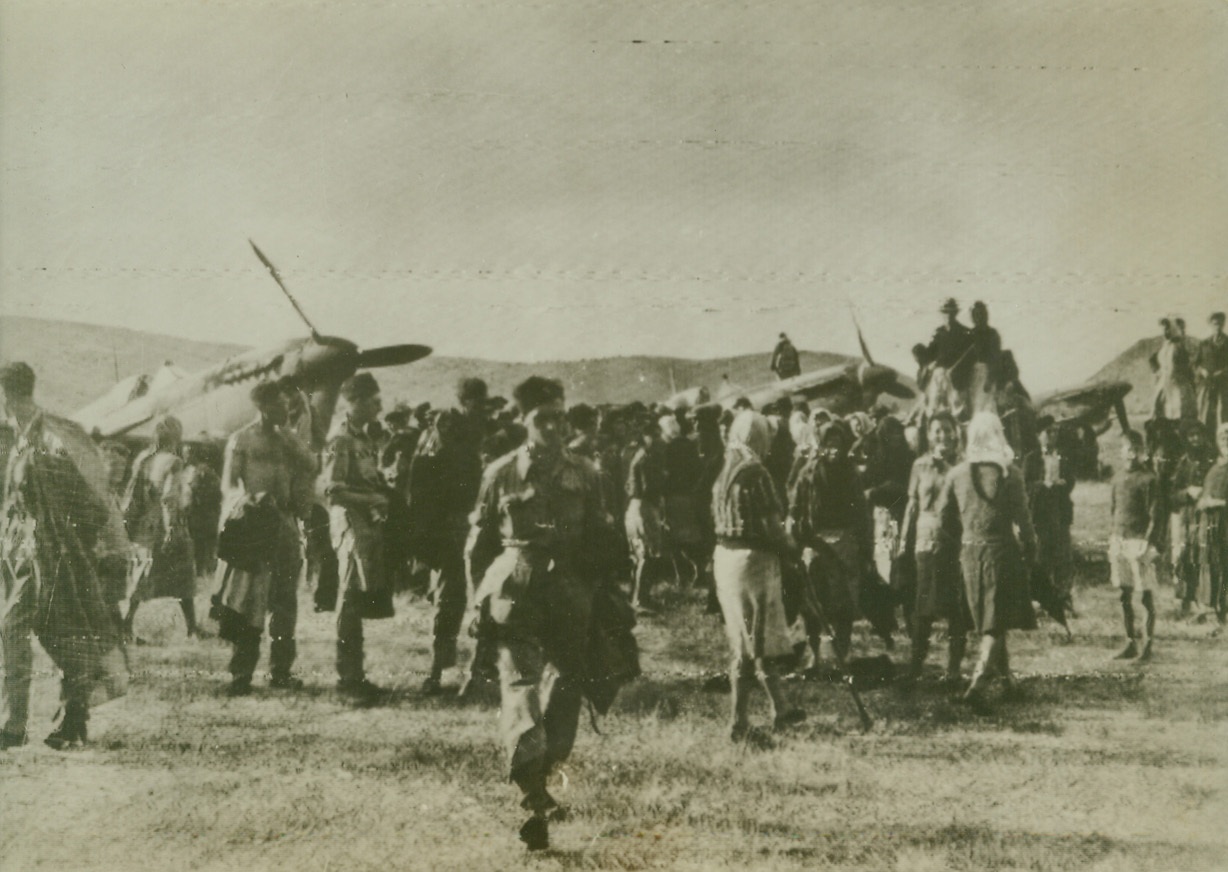 First Photo of Greek Invasion, 10/6/1944. GREECE – Greek civilians joyfully greet RAF crew members on an airfield used by a Spitfire squadron in Greece. It was reported early today that Allied invasion forces are swarming into the country and are now threatening the Nazi garrison at Athens.Credit (British Official Radiophoto via OWI from ACME);