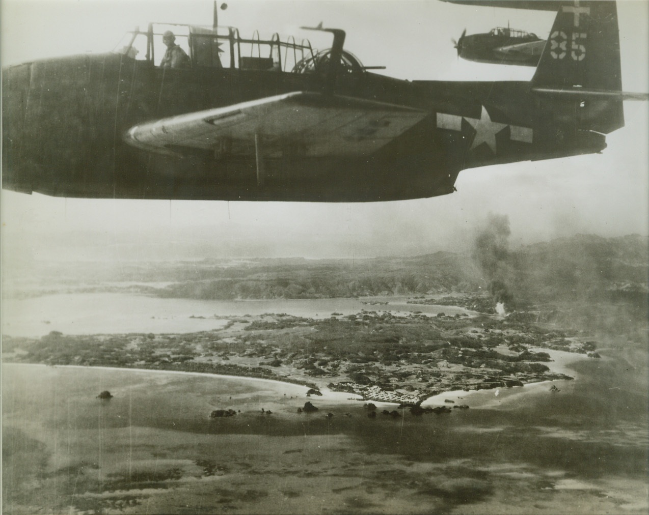 Yank Planes Strike at Ryukyu Islands, 10/18/1944. RYUKYU ISLANDS -- Carrier-based torpedo-bombers from air fleet of Pacific Fleet's great task force range over targets on Okinawa Island in the Ryukyu group which they have bombed and set aflame. U.S. Navy Photo. Credit: (ACME);