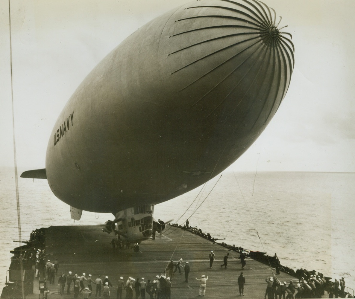 Blimp Makes Carrier Landing, 10/24/1944. Cruising in from a flight, a Navy blimp makes a landing aboard a carrier somewhere at sea. Secured by lines, the blimp nestles toward the deck, its gondola almost touching the broad surface. Credit (U.S. Navy Photo from ACME);