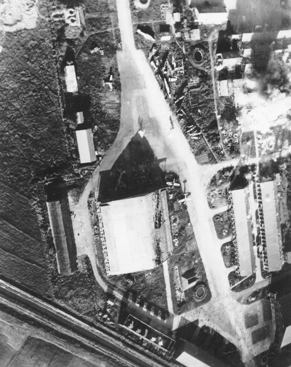 Fromosa Struck By U.S. Fleet, 10/18/1944. Formosa – Japanese planes with the rising sun on their wings are caught on the ground at Kagi, Formosa, by warplanes of the U.S. Pacific Fleet’s fast carrier task force. Large hangar shows effects of attacks. Industrial sheds in upper left billow clouds of smoke as bombs explode from warcraft just pulling out of its dive. More than 97 Jap aircraft were destroyed on the ground during this day of raids on Formosa 10/18/44 Credit Line (ACME);