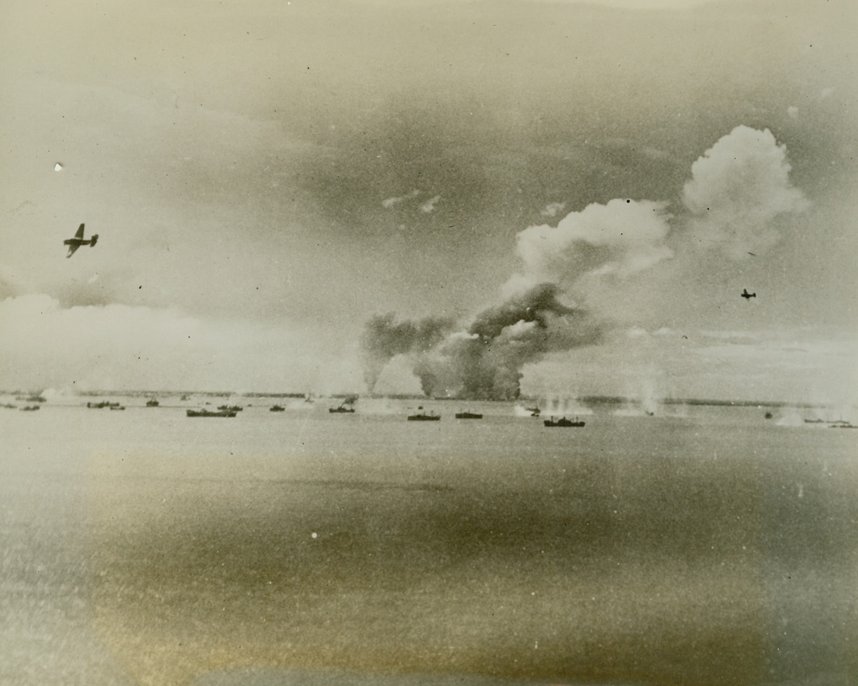 NAVY BOMBERS OVER MANILA BAY, 10/1/1944. MANILA BAY—Two Navy Avenger torpedo bombers of Admiral William F. Halsey Jr.’s Third Fleet, pull up from their attacks on units of the large merchant fleet in Manila Bay. In background, huge curtains of smoke billow from wrecked shore installations. The raid took place on Sept. 20 and 21.  Credit: ACME.;