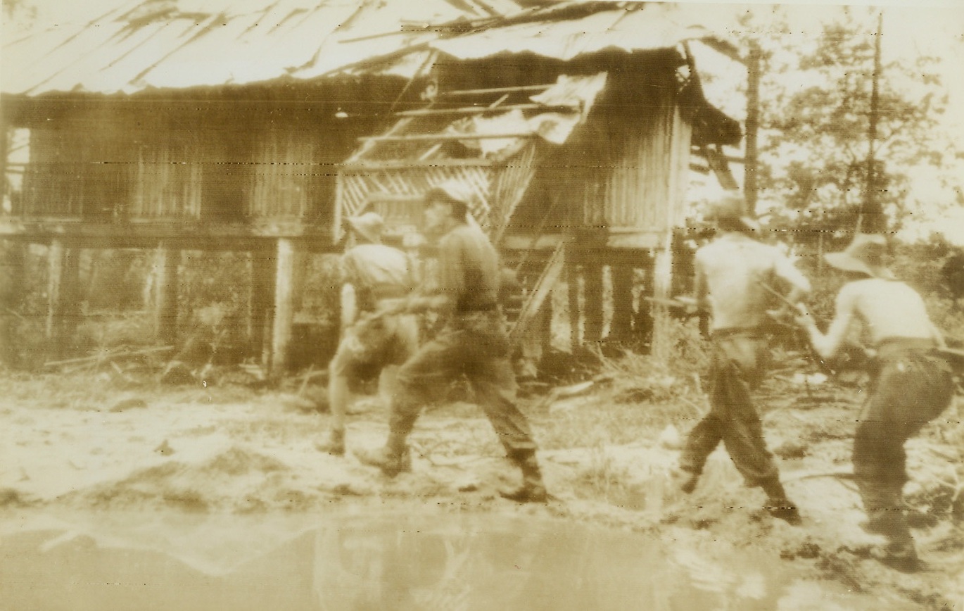 Hunt Enemy Snipers in Burma Village, 10/12/1944. Burma—British soldiers bend low as they advance cautiously through the debris-littered village of Pinbaw in Burma after its capture from the Japanese. These men, stripped to the waist, are members of the Royal Scots Fusiliers.  Enemy snipers are all that remain of a once powerful garrison. Credit (British official radio photo from ACME);