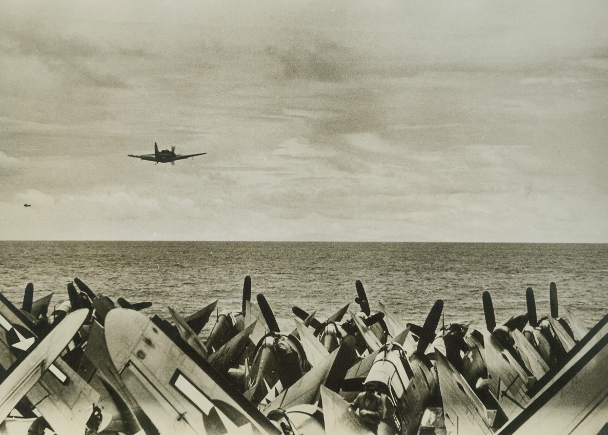 Manila His Target, 10/14/1944. At Sea—a dive bomber takes off for the first U.S. carrier sweep against Manila.  Very faintly in the distance the Luzon mountains can be seen. Credit line (ACME)(WP);