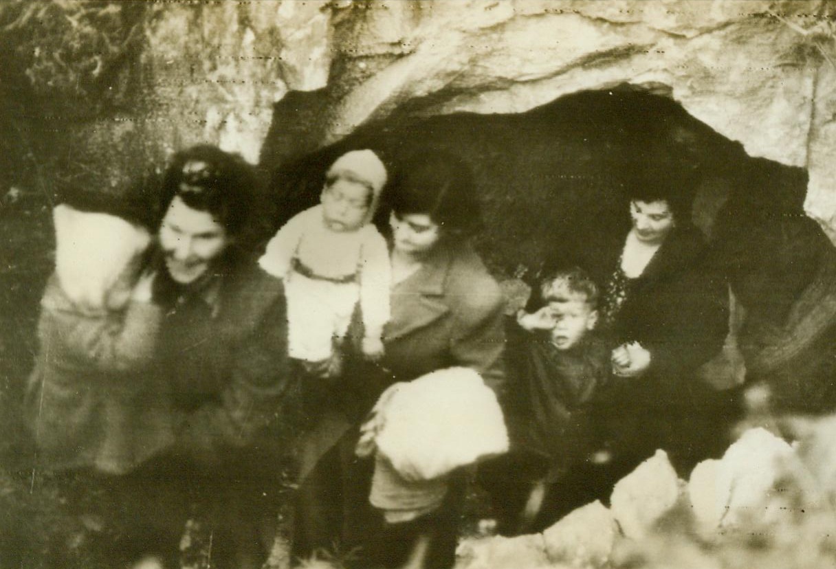 All’s clear – at last, 10/1/1944. DOVER, ENGLAND – Happy in the knowledge that enemy guns, which sent shells screaming over the Channel to Dover during the past four years, have at last been silenced, women and children of the British town leave their cave shelters forever. Two youngsters rub their eyes as they come out into the light. Many children, born during the bitter four years, have known no homes other than the caves. CREDIT (British official radiophoto from ACME) 10/1/44;