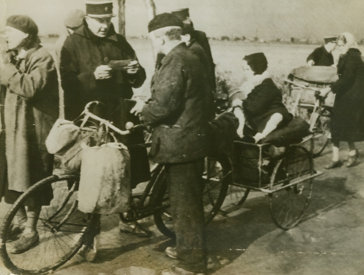 FLEE DUNKIRK DURING TRUCE, 10/7/1944. FRANCE – Between the British and German lines on the soon to become a “no man’s land” at the outskirts of Dunkirk, a French Gendarme checks identity papers of civilians fleeing the city under terms of the truce which allowed the evacuation of residents.  Battle for the port from which 350,000 British soldiers escaped four years ago will soon take on major proportions. Credit: British War office photo via Army radio telephoto from Acme;