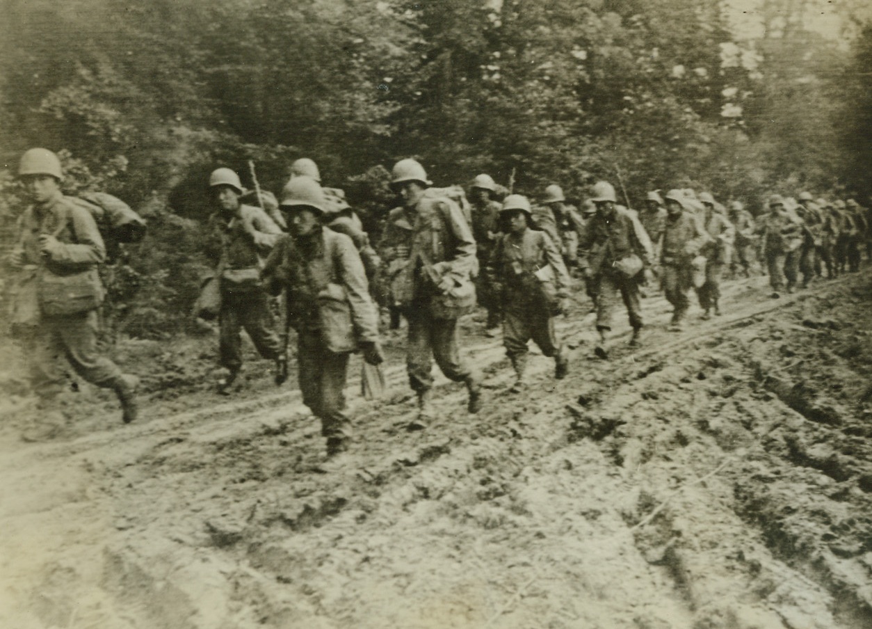 CLAIM NO KINSHIP, 10/20/1944. FRANCE—As Americans smash their way into the Jap’s temporary bastion in the Philippines, these loyal Japanese-American infantrymen slog through the mud of France to join other Allied forces in the battle to conquer Germany. Credit (Army Radiotelephoto from ACME);