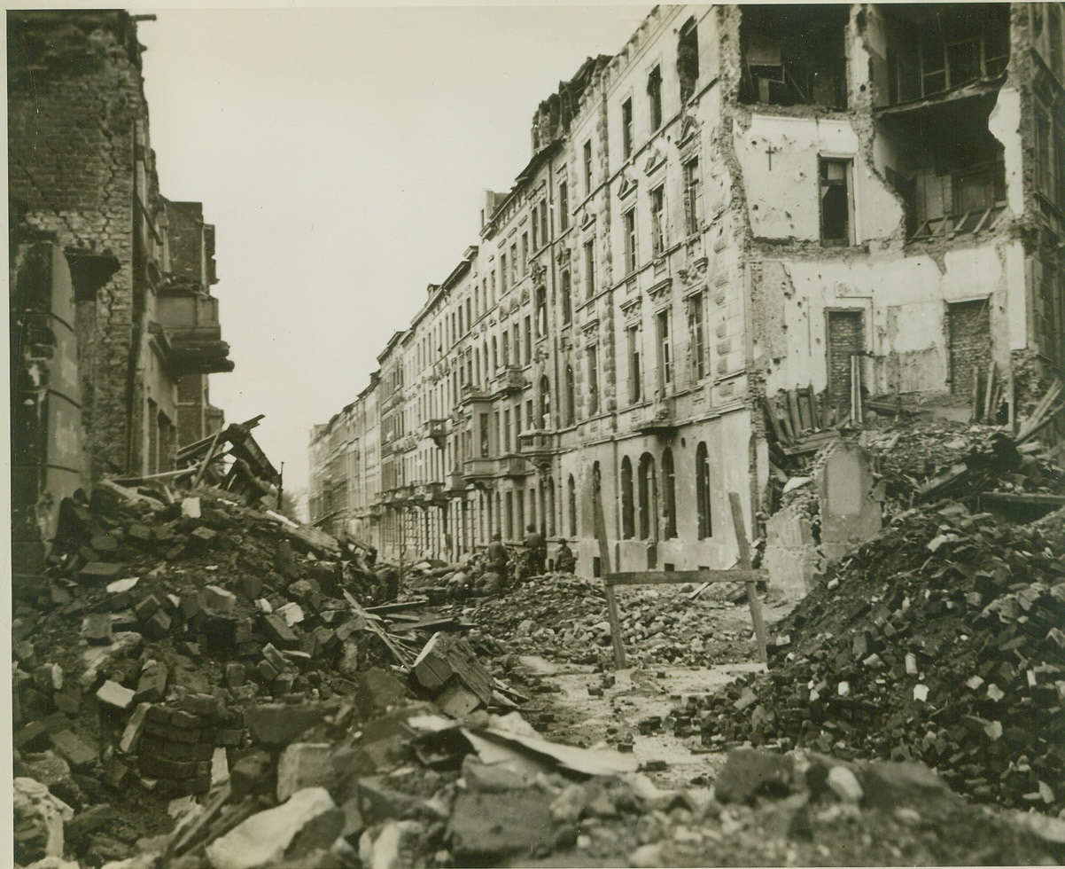 Blasted Aachen, 10/18/1944. Huge piles of rubble fill this street in battle-smashed Aachen, Germany. Many historic buildings were leveled in the heavy shelling and aerial bombardment which preceded Yank entry. Credit: (ACME);