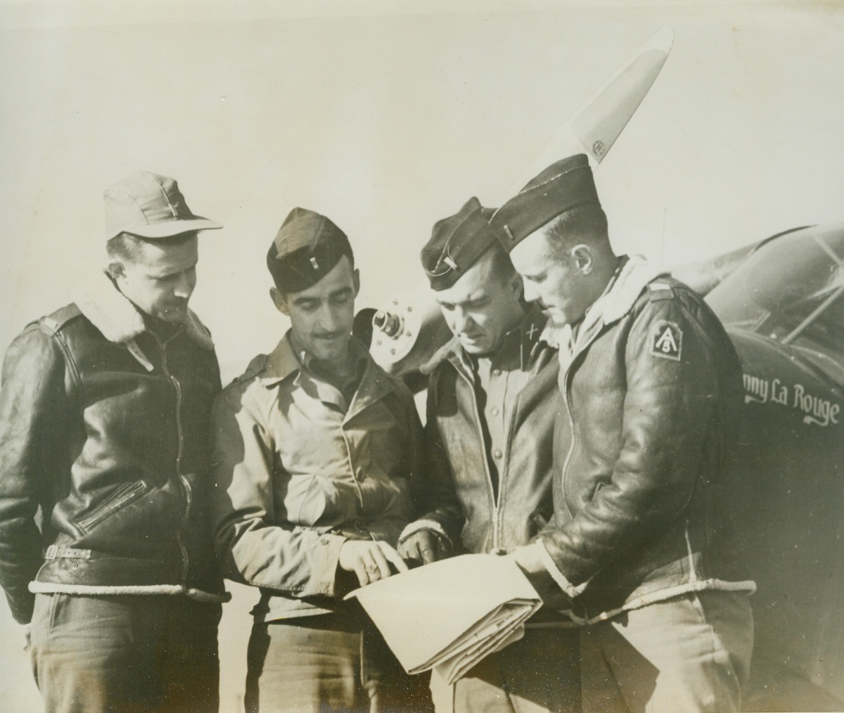 Ready for the Next Leap, 2/7/1944. Italy – Yank pilots flying Cubs in Italy trace their next mission. (left to right) 2nd Lt. W. Holden, Jr., of Baltimore, Mad.; 2nd Lt. Dick Cummings, of Ames, Ia., D.F.C.; 2nd Lt. Oved S. Essary, Dallas, Texas, and 1st Lt. Richard W. Blake, of La Salle, Colo. Credit: (ACME);