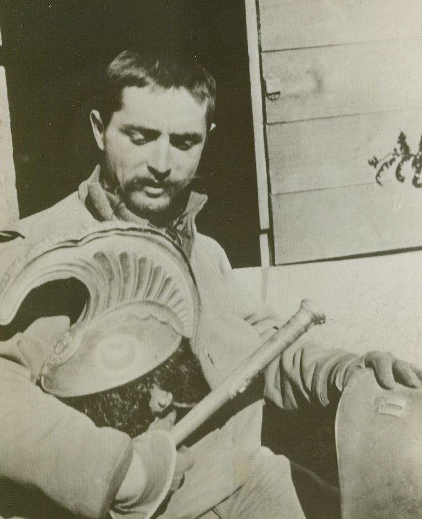 Ancient and New Helmets, 2/1/1944. Italy: Capt. Frederick J. Saam, of Calumet, Mich., presents a contrast in the two epochs of war, which the town of Anzio, Italy has witnessed with the ancient Roman helmet in his right hand and his own 20th century helmet in his left hand. Credit: U.S. Signal Corps radiotelephoto from ACME.;