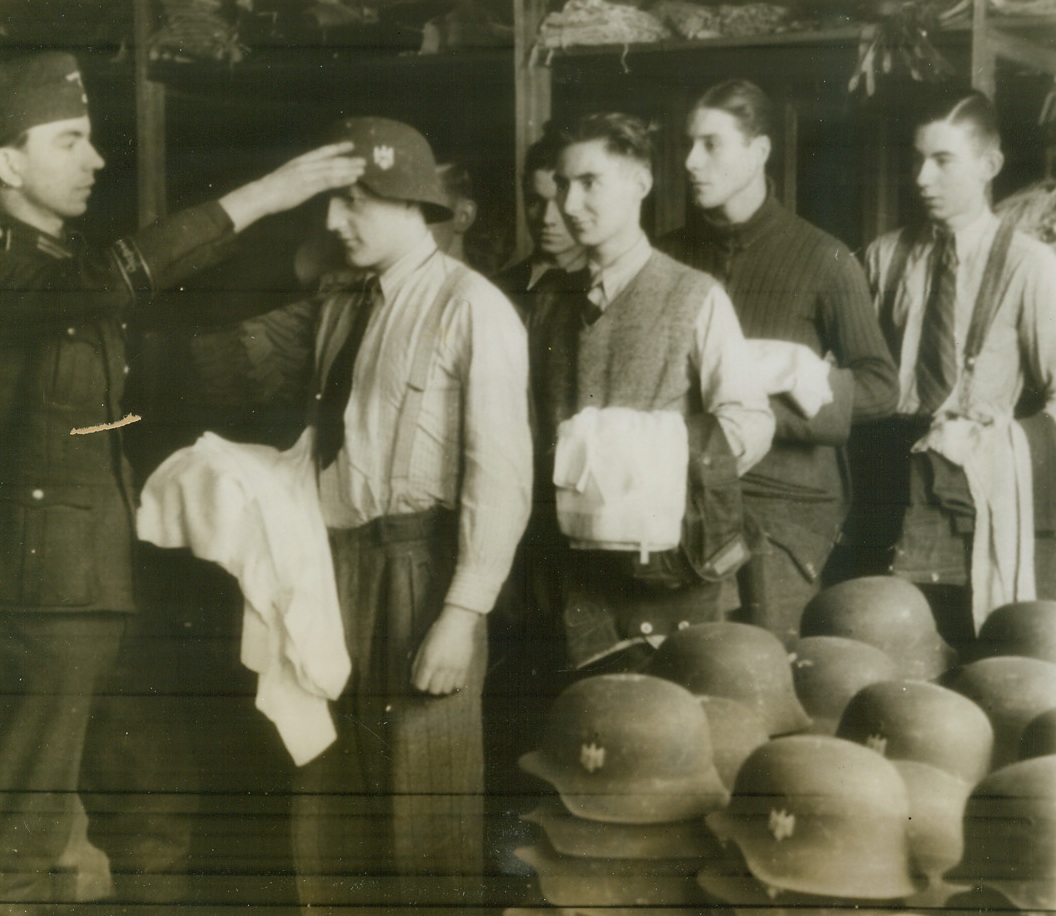 Youth Must Serve, 2/2/1944. Germany—Volunteers for Germany’s so-called “Gross Deutschland,” many of whom are obviously in their mid-teens, are shown receiving their clothing issue in a town where the division is stationed. Looks as if Germany is determined to use her very last drop of manpower in this war before giving up the struggle. Photo radioed from Stockholm this morning. Credit: ACME radiophoto;