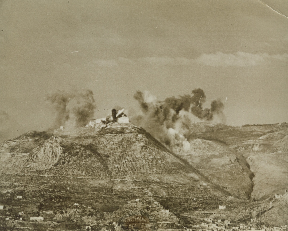 We Fire Cassino Abbey, 2/25/1944. ITALY – Long immune from Allied guns, the Benedictine monastery is enveloped by smoke and flame as waves of Allied bombers fire the retreat, used by the Nazis as a fortress, on the tip of Mount Cassino. The Allies trained their guns away from the abbey until it was obviously necessary, from a military point of view, to shatter the buildings used by the Germans to great advantage over our fighters in the valley below.Credit: (ACME);