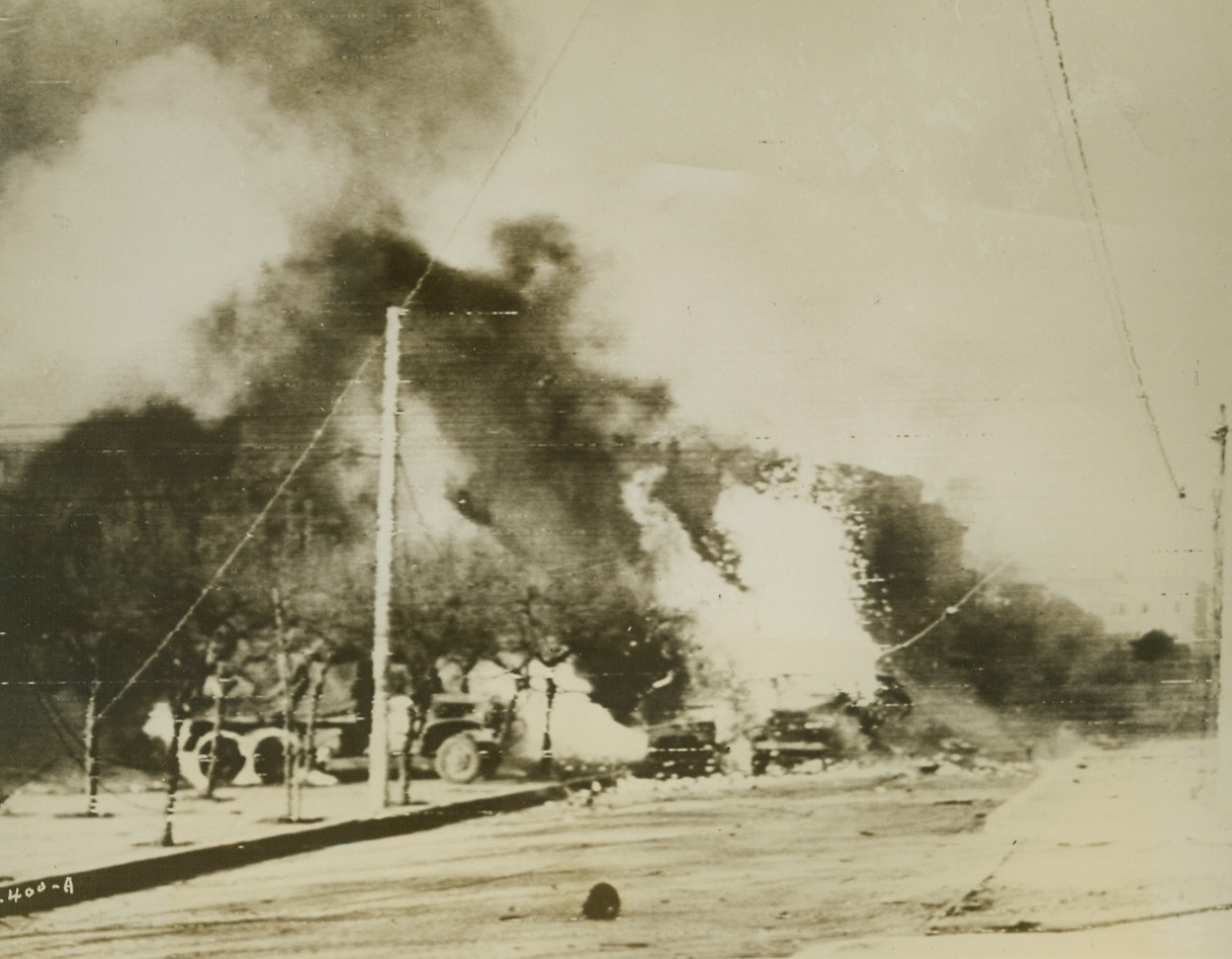 Nazi Planes are Active, Too, 2/14/1944. ITALY – American and British trucks burst into flames, the victims of a Nazi air attack in the embattled Nettuno area. Nazi bombs set off the blaze which is fed by the vehicles’ fuel tanks. Our planes are giving the same sort of treatment to enemy supply dumps and roads.Credit (Signal Corps Radiotelephoto from Acme);