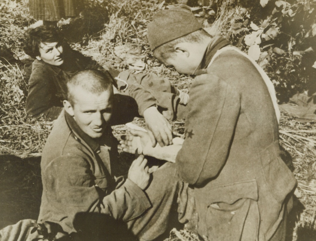 American-Born, He Fights with Tito, 2/9/1944. Yugoslavia – Among the men battling Hitler’s forces in the Balkans is this American-born Yugoslav doctor, known as “John.” Attached to the First Serbian Brigade, he attends to Partisan warriors wounded as they fight under Marshal Tito. Credit Line (Acme);