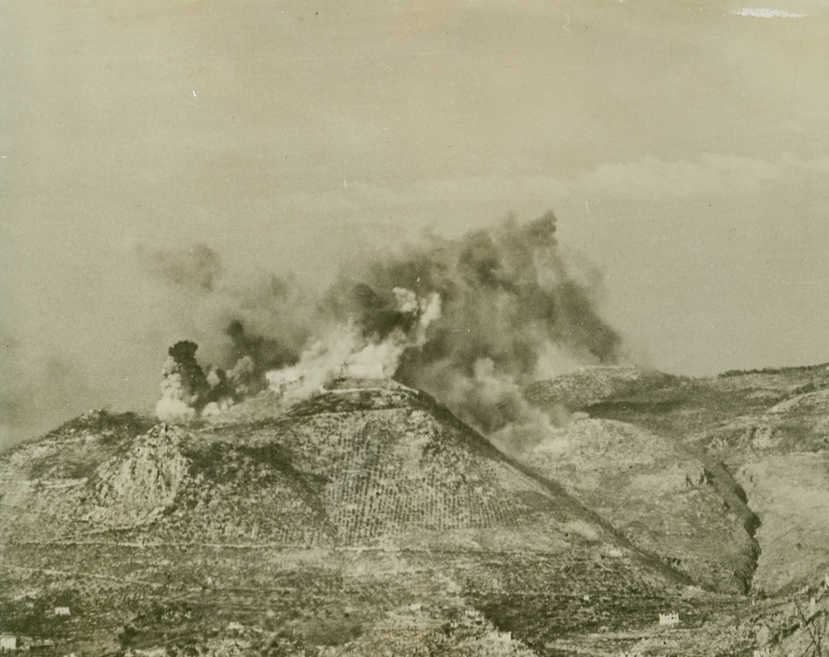 FORTIFIED MONASTERY BATTERED BY ALLIES, 2/25/1944. ITALY—The famous Benedictine monastery on the peak of Mount Cassino is turned into a smoke-shrouded inferno by Allied bombers. Explosives were followed by incendiaries, as some 250 medium and heavy bombers knocked out the religious building which the Nazis had turned into a fortress used to shell Allied troops. Credit: Acme;